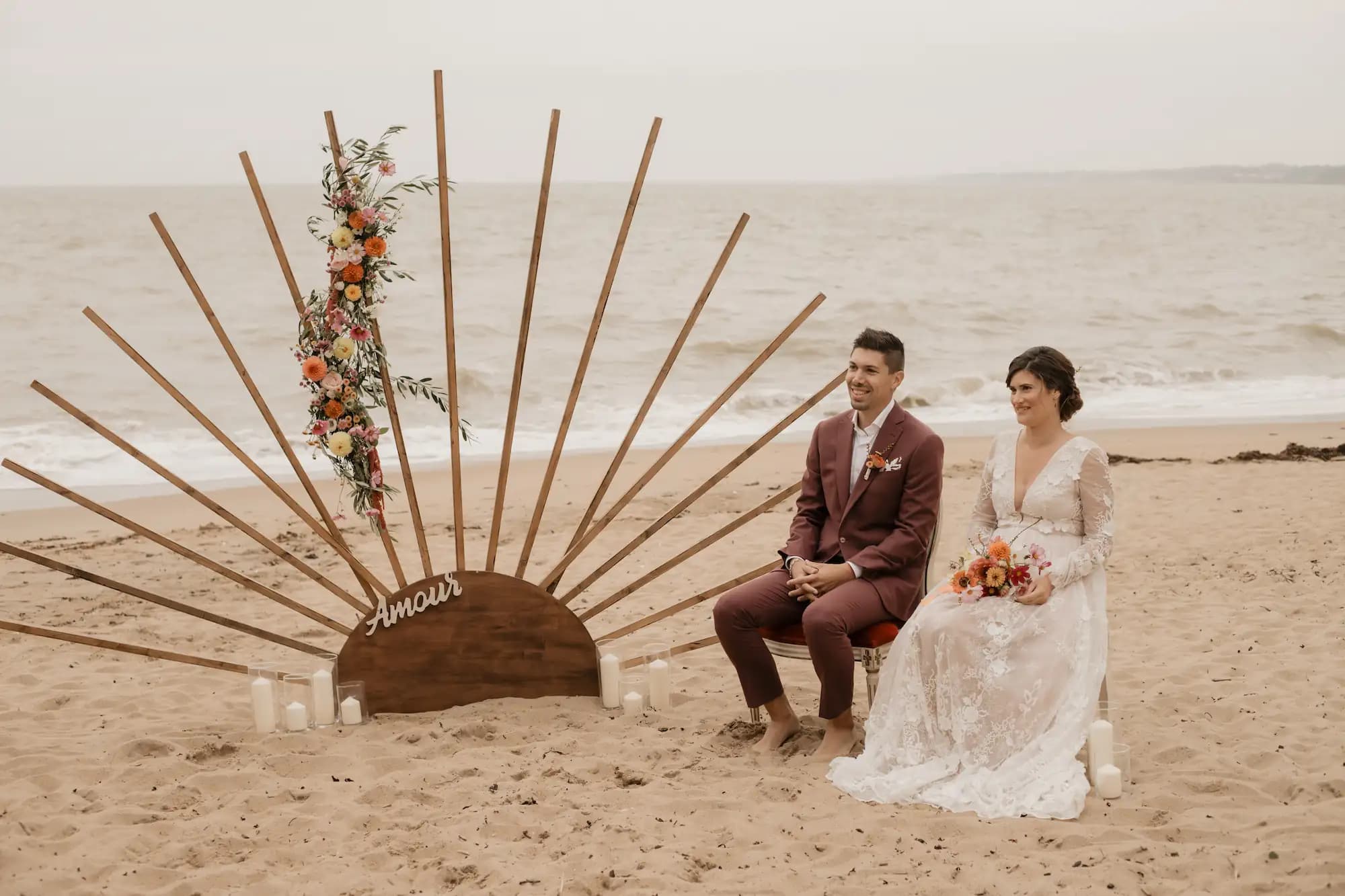 Cérémonie laïque sur la plage devant une arche soleil en bois créée sur mesure