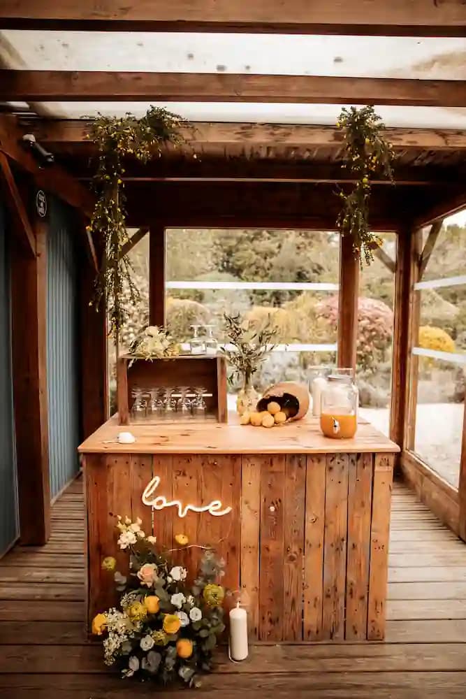 Bar à cocktails en bois habillé de fleurs jaunes et orangées