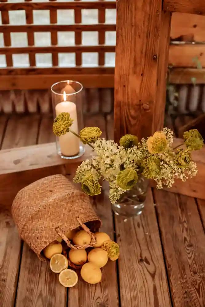 Citrons dans un panier en osier et photophore sur une table en bois