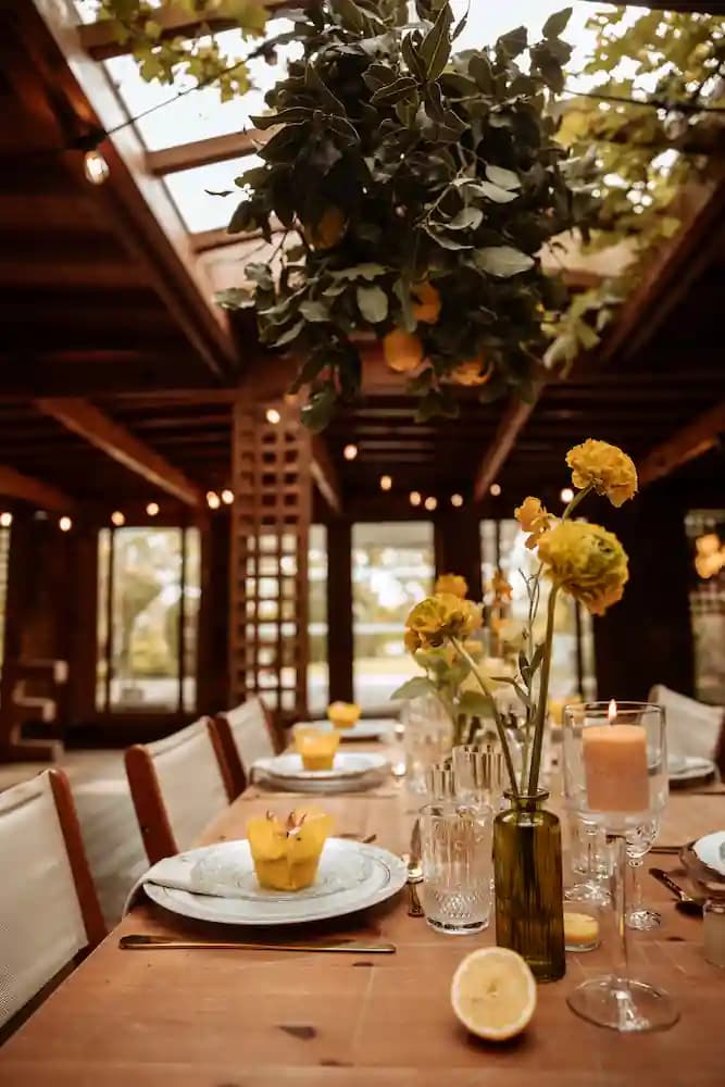 Table Dolce Vita avec soliflores jaunes, bougies et citrons