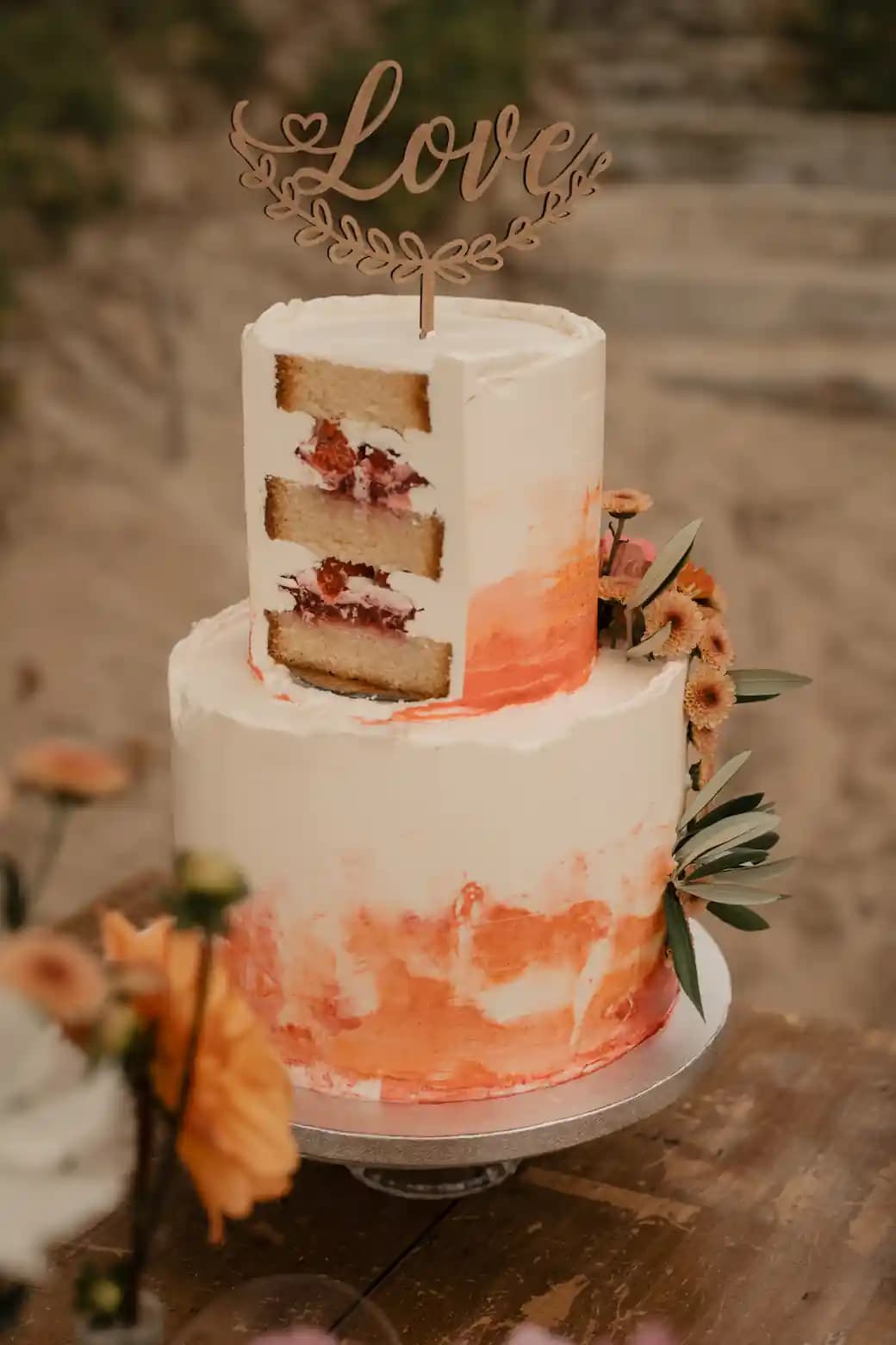 Wedding cake aux touches orangées surmonté d'un topper « Love »