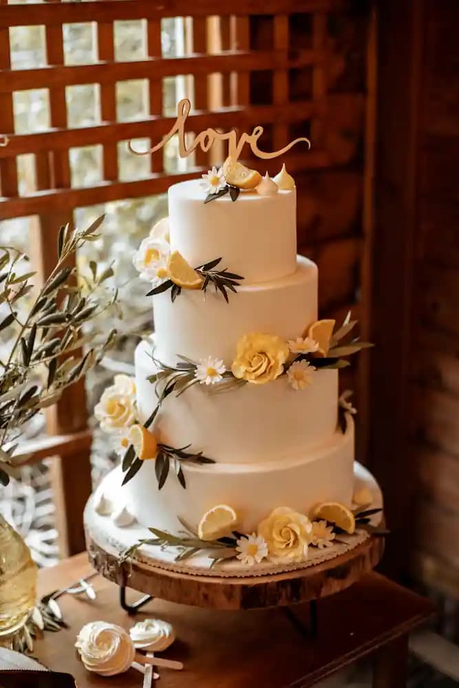 Wedding cake sous un néon « Let's celebrate » et un treillage en bois